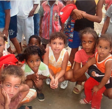 MotasFaces Founder Sitting With Children Of The Dominican Republic