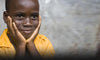 Child Holding Face Looking Hopeful